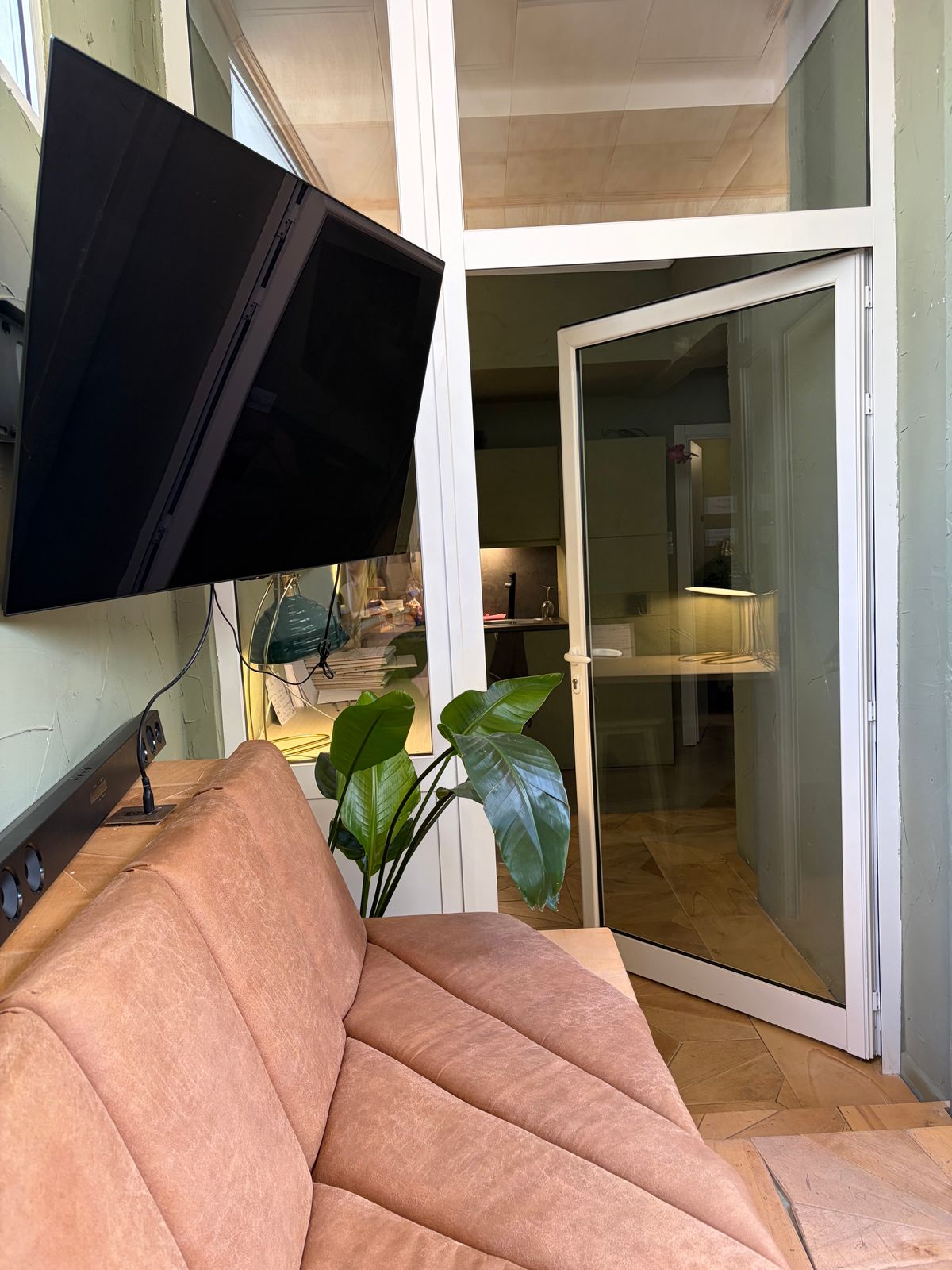 The mounted screen in the Amphitheatre, above the velvet seating, beside the glazed door through to the rest of the house.